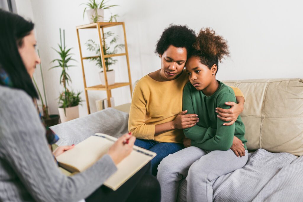 Mother and her teenager daughter talking with therapist.