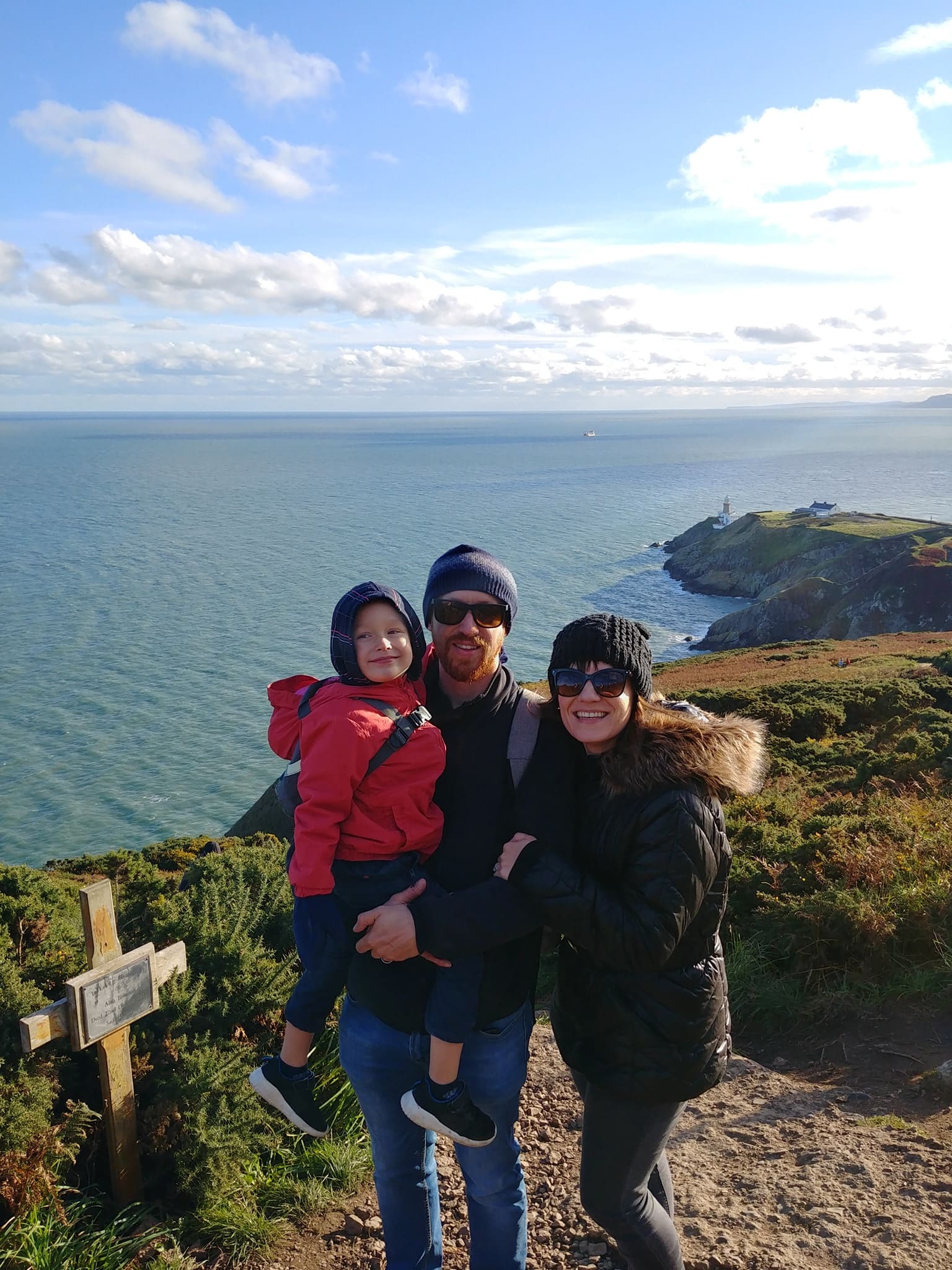 Family of 3 posing in front of scenic view