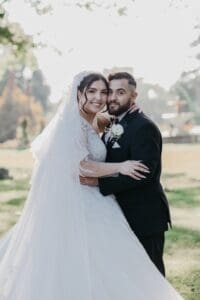 Bride and groom posing outdoors at their wedding